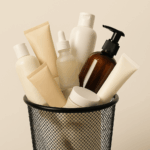 A variety of skin care products discarded in a mesh garbage bin.